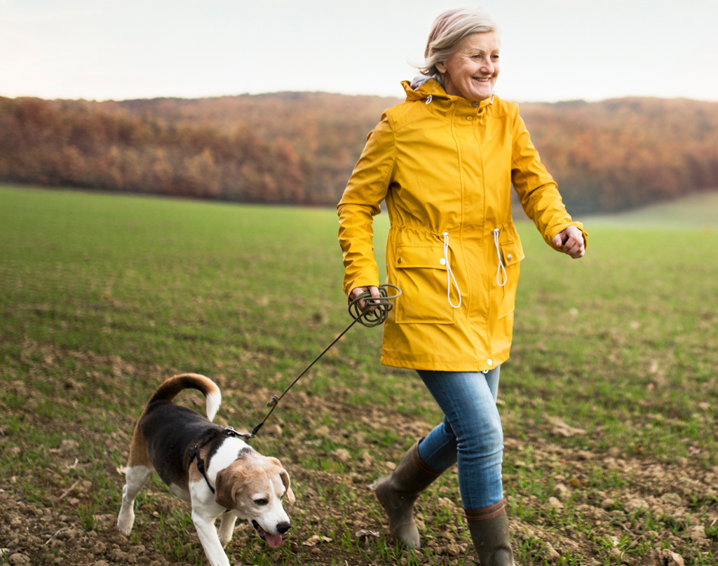 Older woman walks her dog with relaxed feet